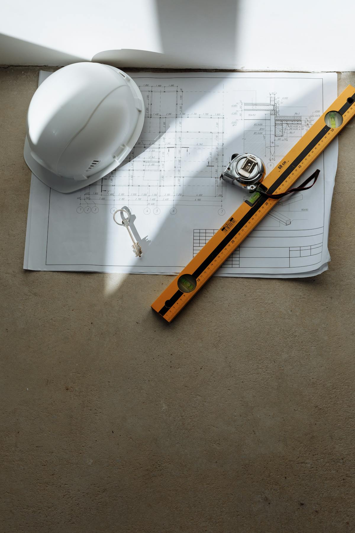 Construction blueprint with safety helmet and spirit level for a deck permit plan