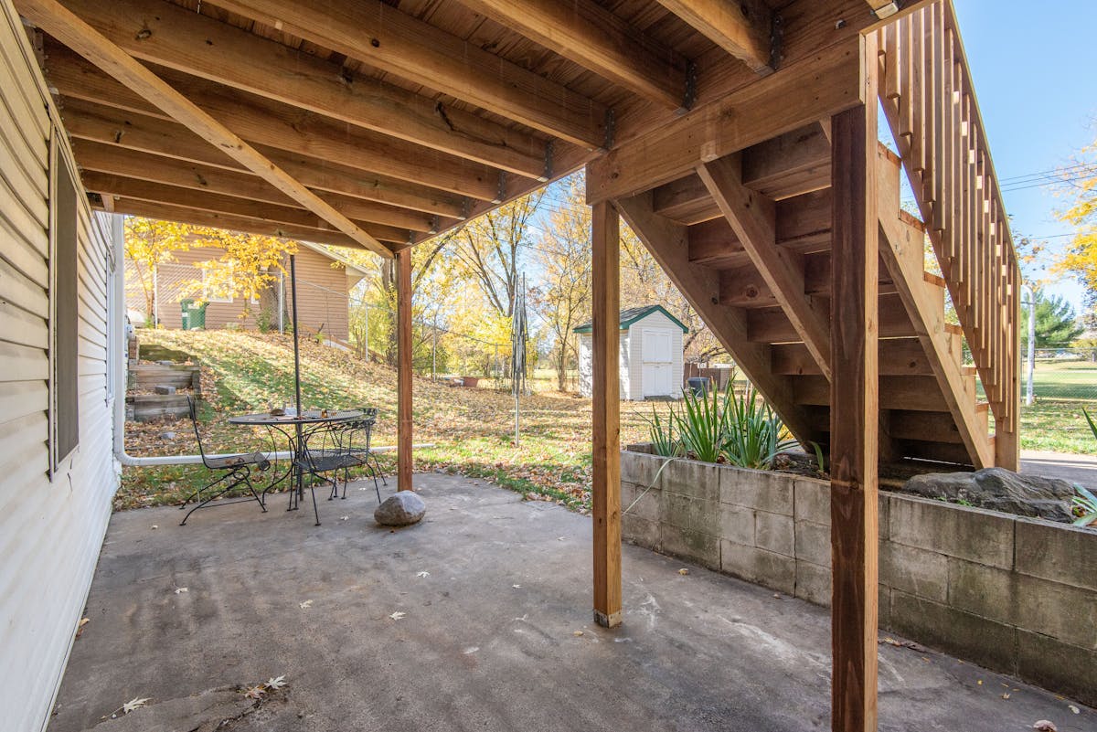 Wooden deck stairs attached to a house exterior showing a ledger attachment area